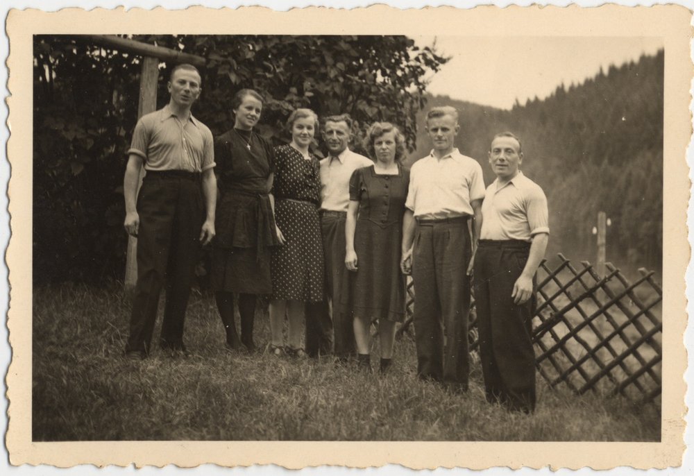 Fotografie: Von links: Jurek Rozenek, Frieda Löser, Luise und Alfred Griesmann, Margarete und Arno Bach sowie Michał Rozenek im Garten des Hauses Dorfstr. 40, Niederschmiedeberg, Juni 1945