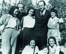 Oskar Schindler (standing, 4th from left) and some of those he rescued, including Marianne Rosner (1st from left) and Aleksander Rosner (seated, center), Munich, 1946.