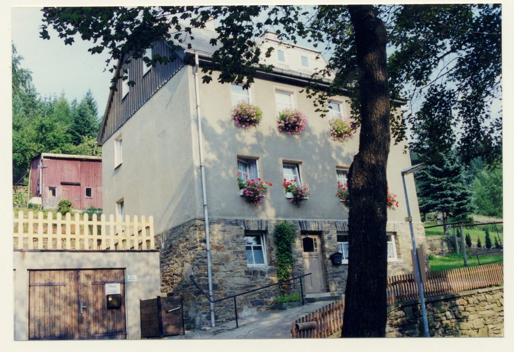 Fotografie: Das Haus Dorfstraße 40, im Hintergrund der Schuppen, in dem Michał und Jurek Rozenek versteckt waren, Niederschmiedeberg 1999