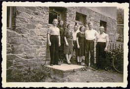 Fotografie: Von links: Jurek Rozenek, Frieda Löser, Luise und Alfred Griesmann, Margarete und Arno Bach, Michał Rozenek vor dem Haus Dorfstr. 40 in Niederschmiedeberg, Juni 1945