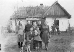 The Gerasimchik family outside their house in Shubkiv after their liberation. Back row, right to left: the sisters Galina and Klavdiya, their mother Lyubov, two relatives, front row: foster-daughter Sinaida Shpak and Pavel Gerasimchik (seated).