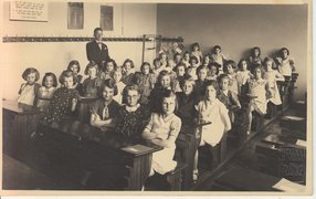 Eva Löwidtová (2nd row, 1st from right) in third grade, shortly before she had to leave her state school, Prague, 1939.