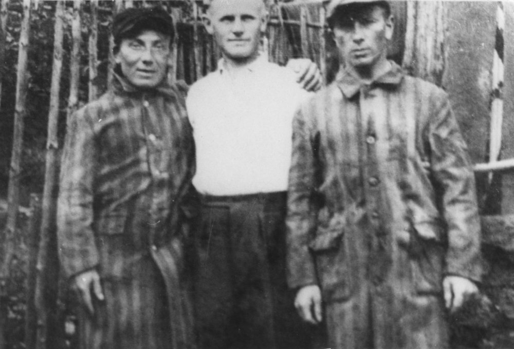 Fotografie: Jurek und Michał Rozenek mit ihrem Retter Arno Bach kurz nach der Befreiung vor dem Holzschuppen, Niederschmiedeberg 1945