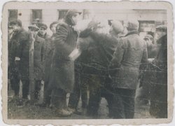 Ein junger Mann reicht Ajzyk Wierzbicki (Mitte) Schmuggelware über den Zaun des Warschauer Ghettos, um 1940