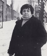 Stella Müller-Madej outside the gates to the former Auschwitz concentration camp, undated.
