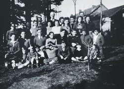 Kinder und Jugendliche mit Betreuer*innen vor dem Kinderheim „Les Grillons“, darunter Peter Feigl (hintere Reihe, 2. von links) und der Heimleiter Daniel Trocmé (hintere Reihe, rechts, teilweise verdeckt), Le Chambon-sur-Lignon 1943