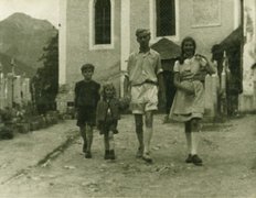 Fotografie: Eduard Bäumer mit seinen Kindern Angelica (rechts), Bettina und Michael in Großarl vor der Kirche, August 1944