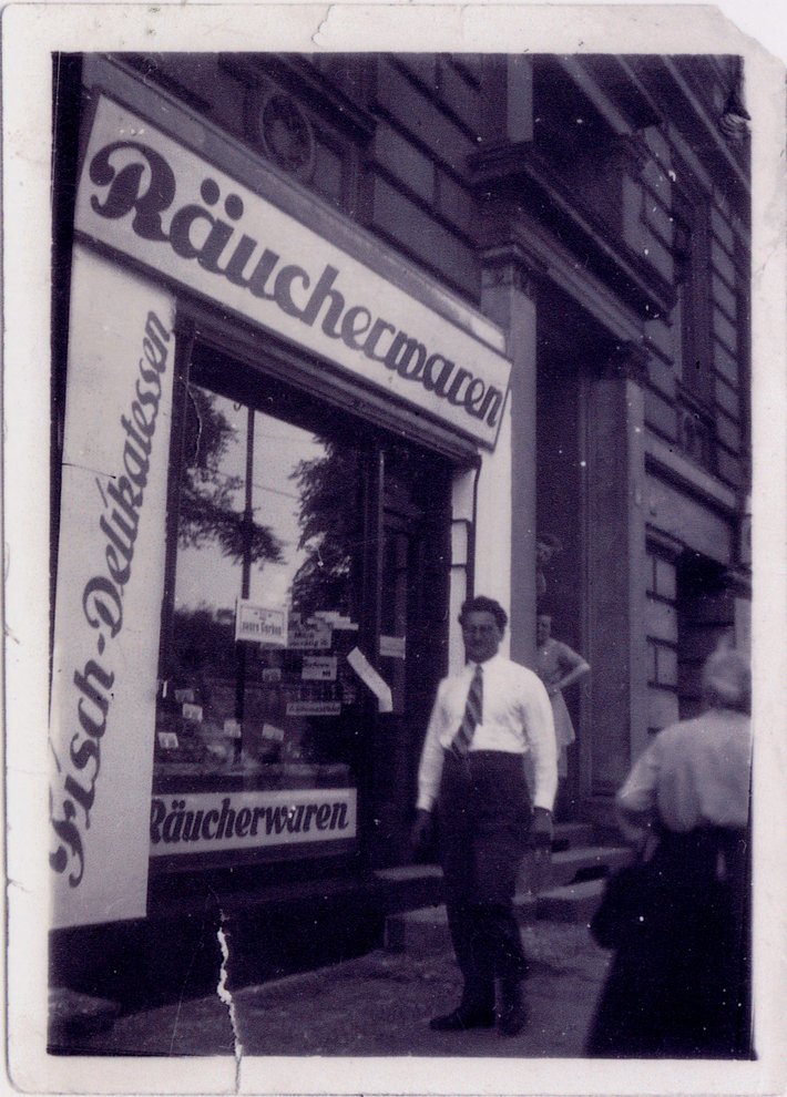 Fotografie: Der Räucherwarenladen von Christine Engler in Berlin-Schöneberg, Flottwellstraße 5, mit unbekannten Passant*innen, Berlin 1944